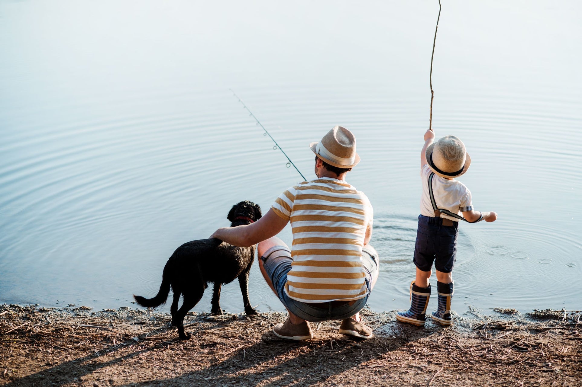 Pet parent fishing with son and dog